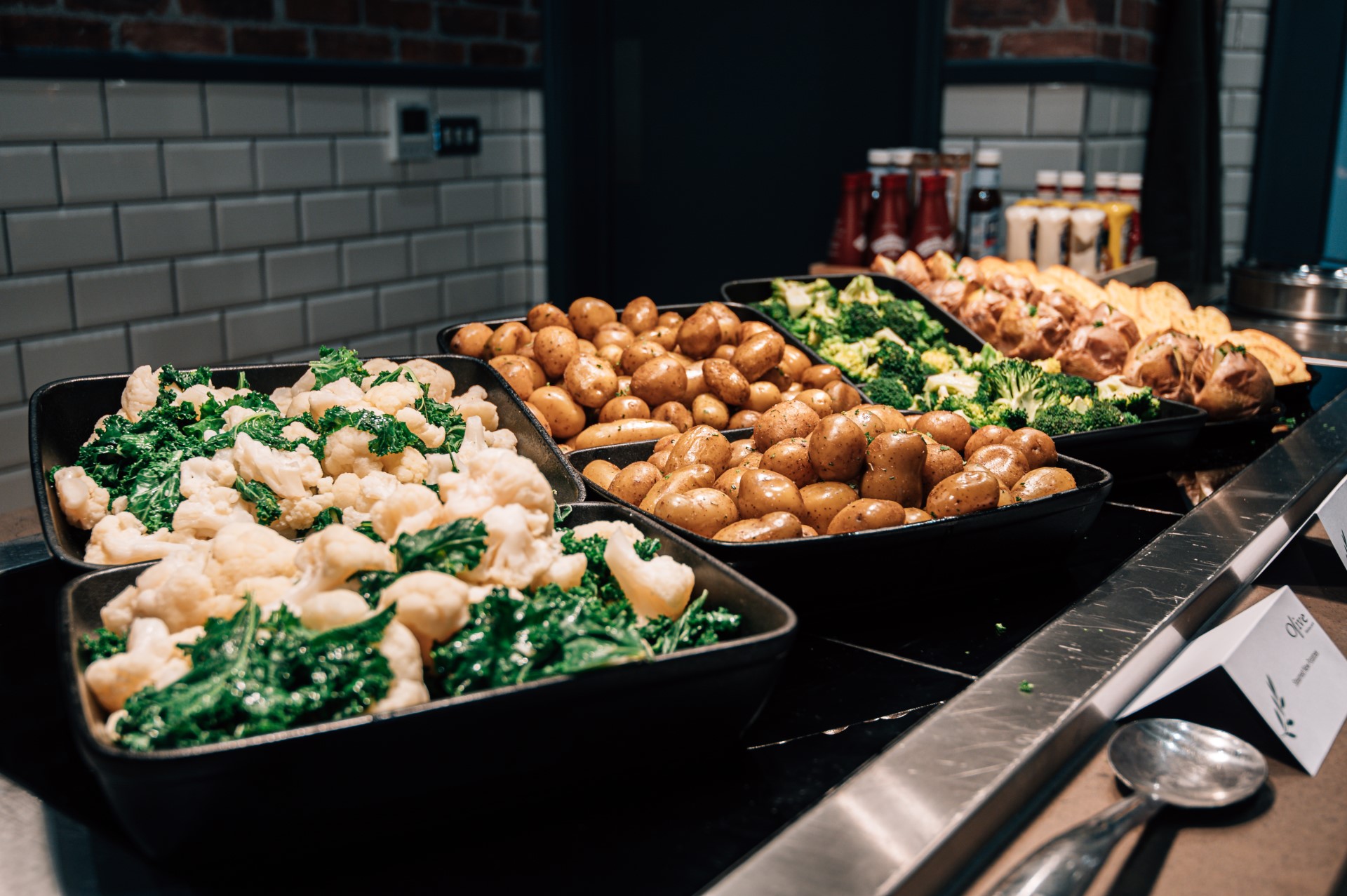 fresh vegetables and potatoes in black trays