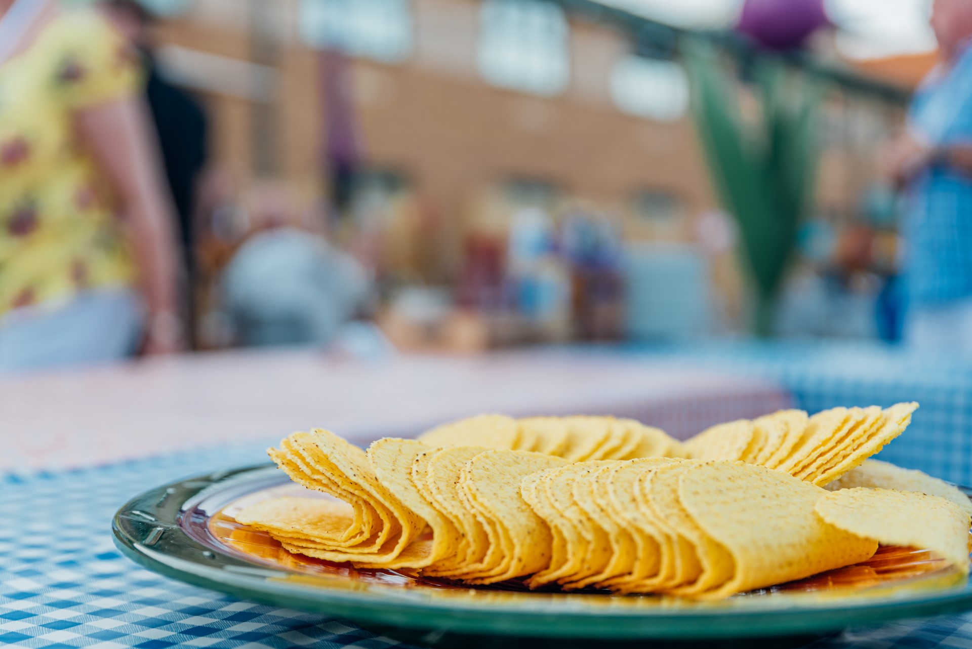 plate of stacked round tortilla chips on tablecloth
