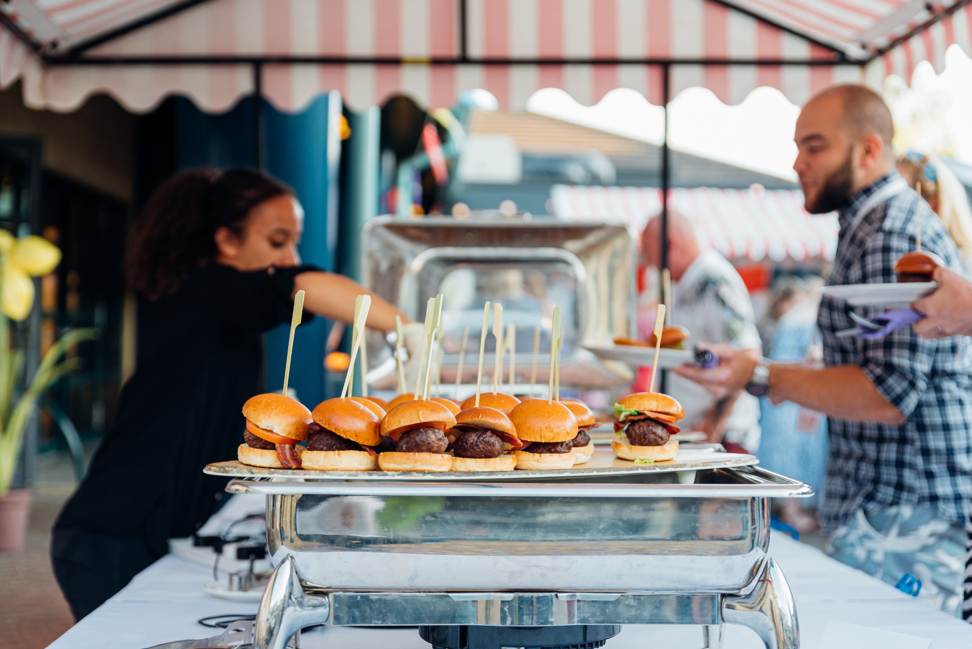 mini burgers on silver tray at buffet outdoor event