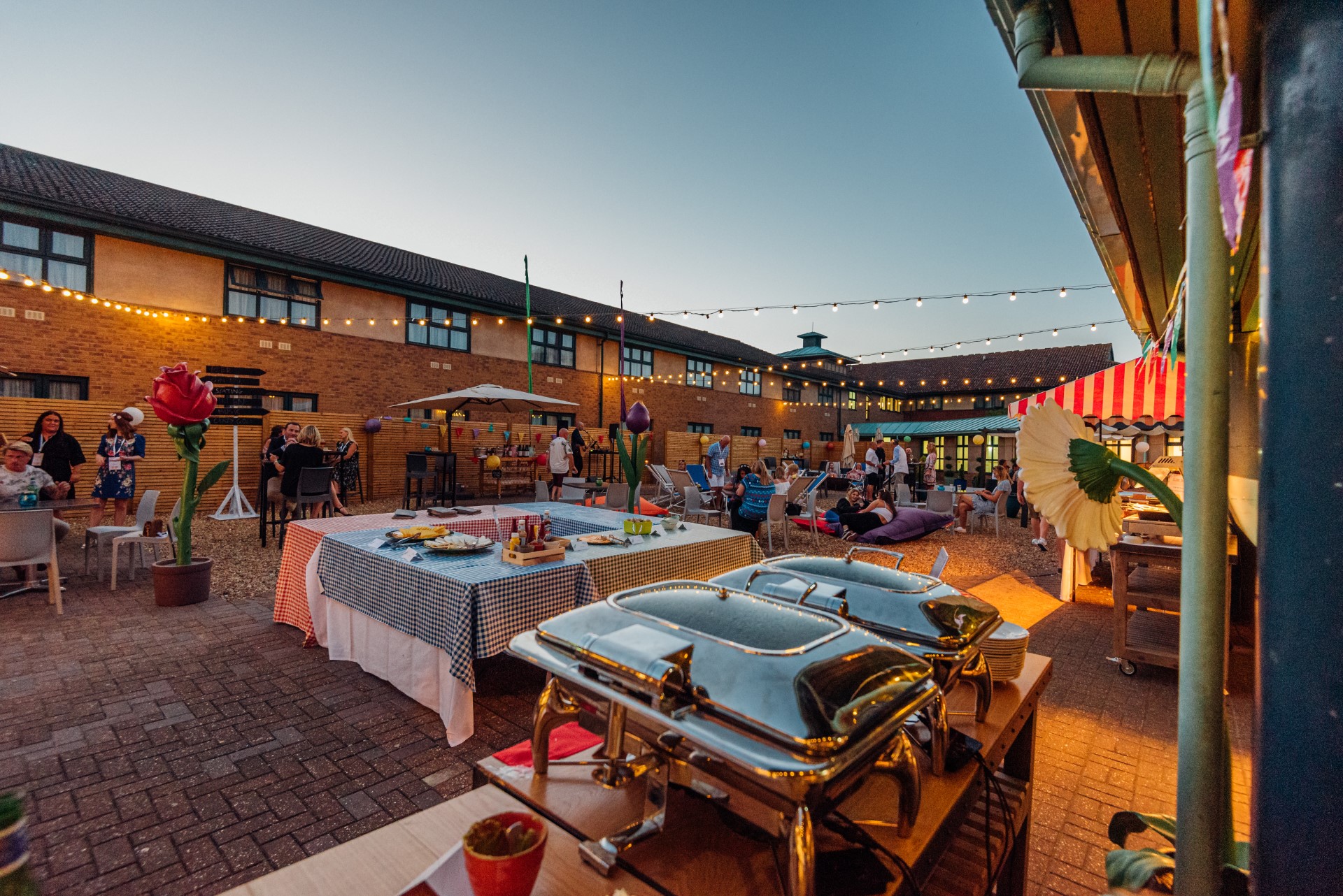 outdoor evening party with buffet and guests mingling