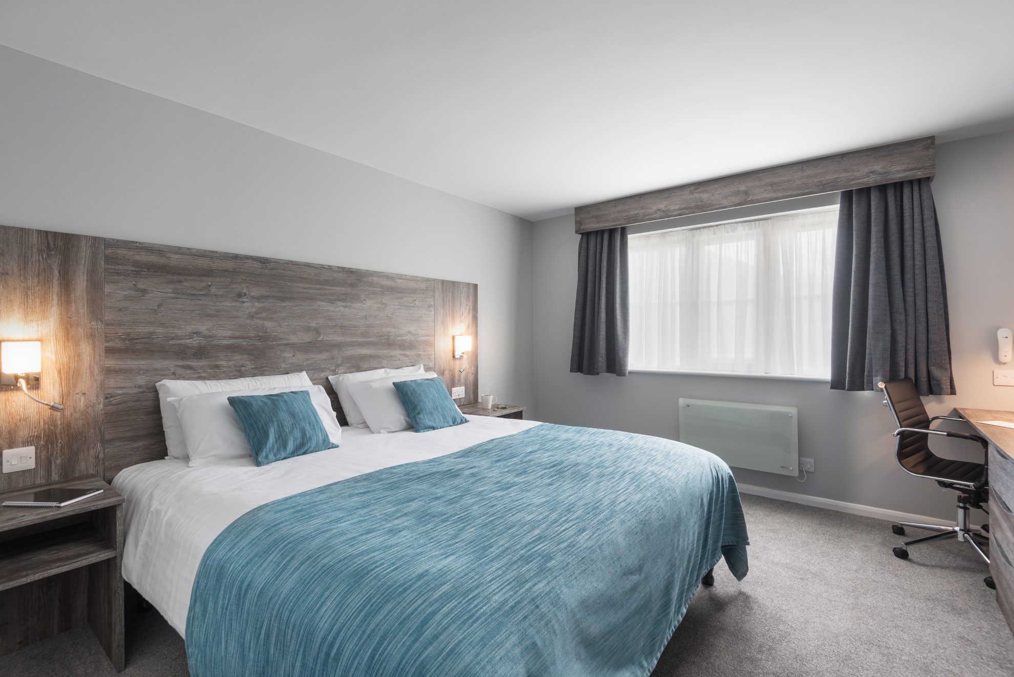 bedroom with double bed blue bedding and desk chair