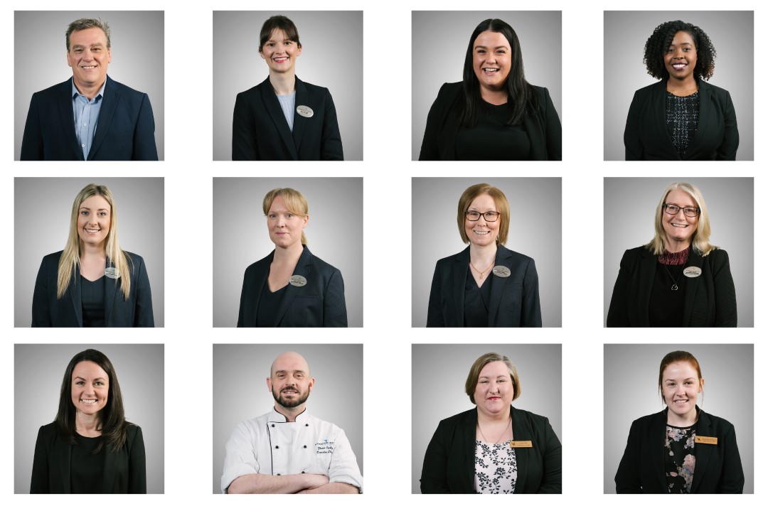 twelve professional people wearing work uniforms smiling