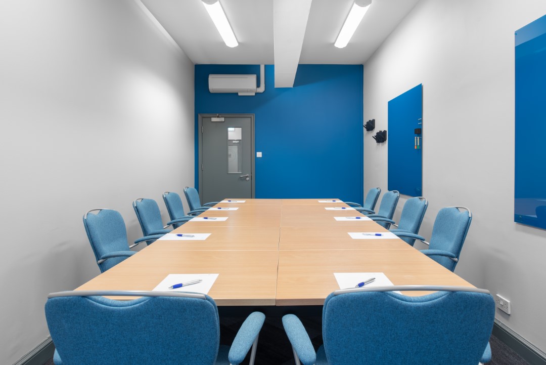 empty meeting room with blue chairs and wooden table