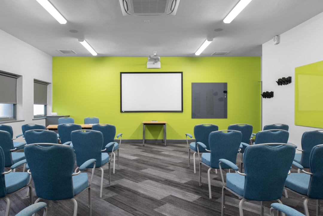 empty conference room with blue chairs and projector screen