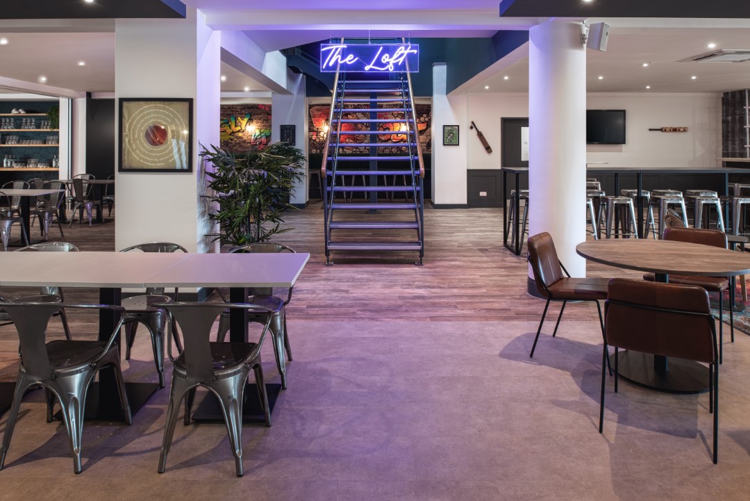 modern loft interior with metal stairs and neon sign