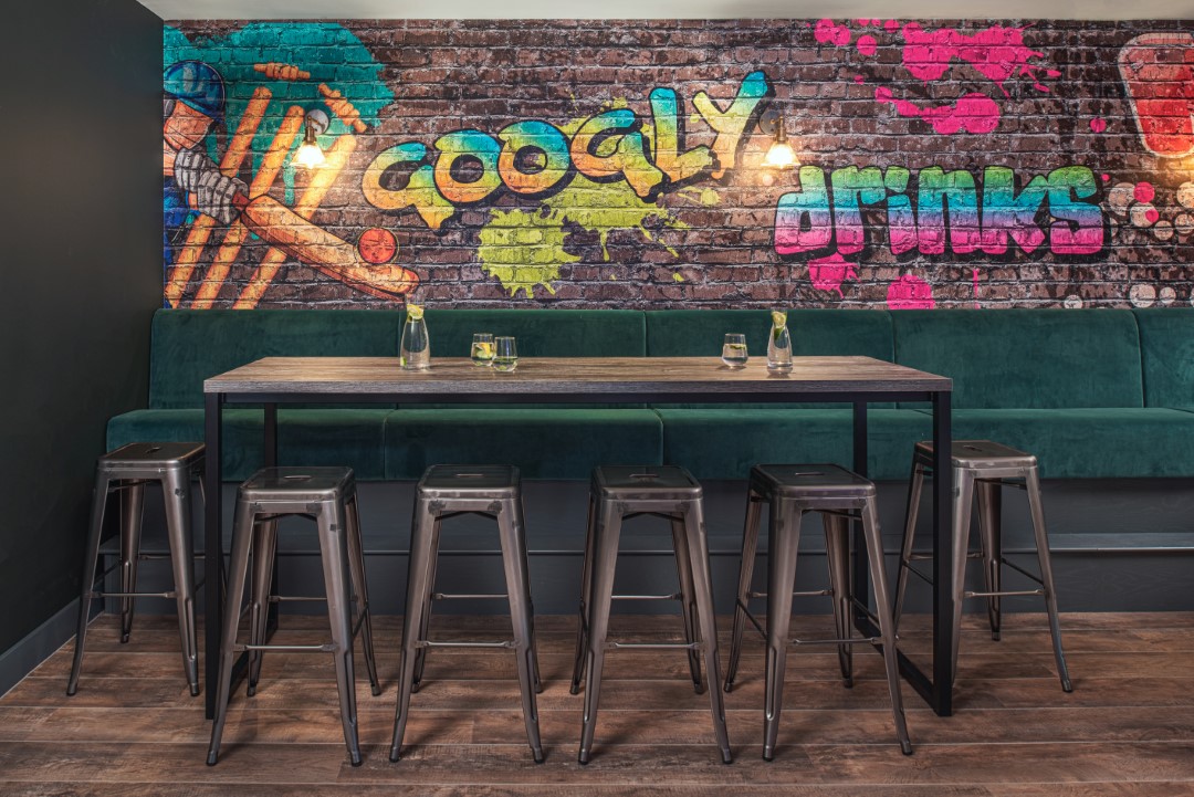 empty modern bar table with stools and graffiti wall