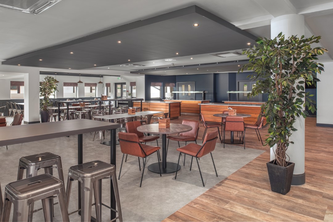 modern cafeteria with tables chairs and bar stools