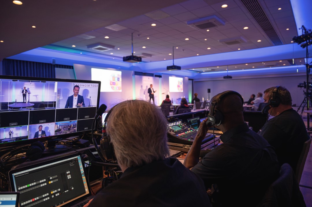 people controlling video and sound at conference room