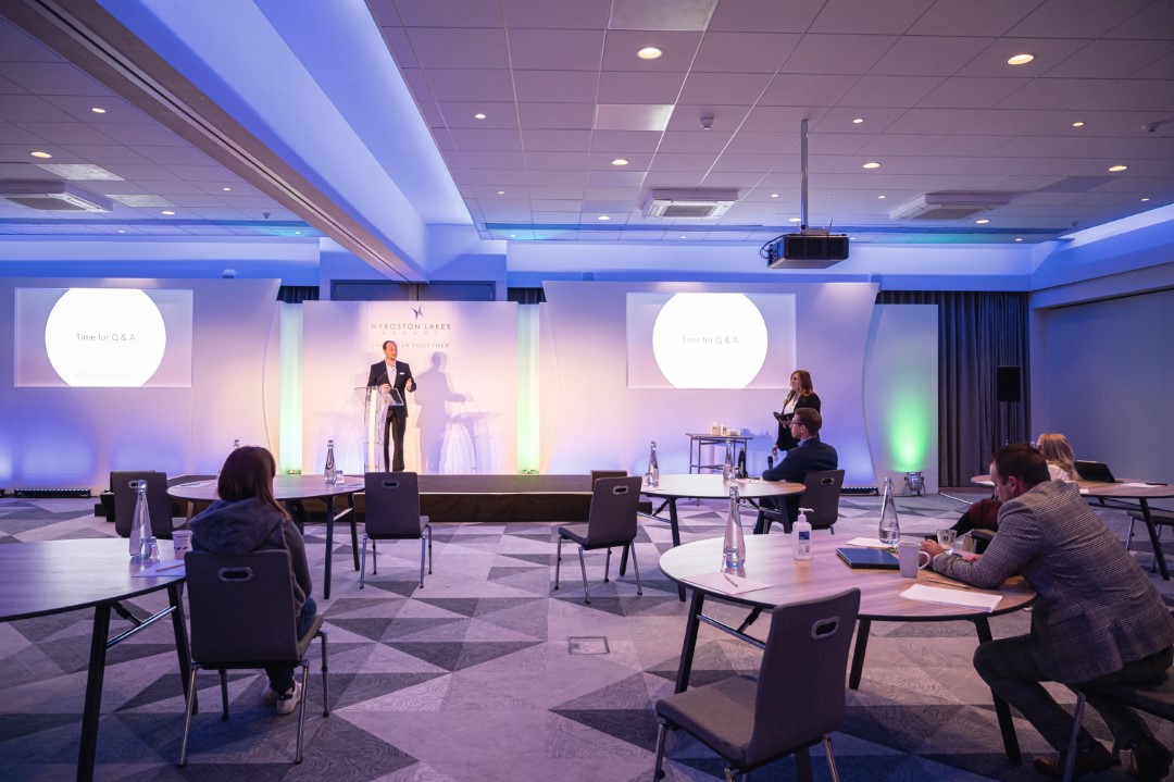 conference room with social distancing and speaker on stage