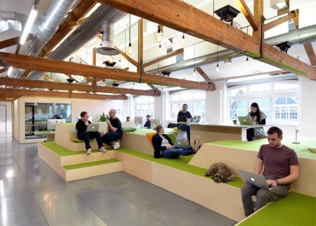 open plan office with wooden beams and people working