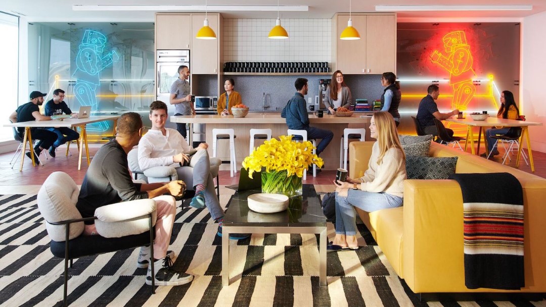 modern office lounge with people chatting and working