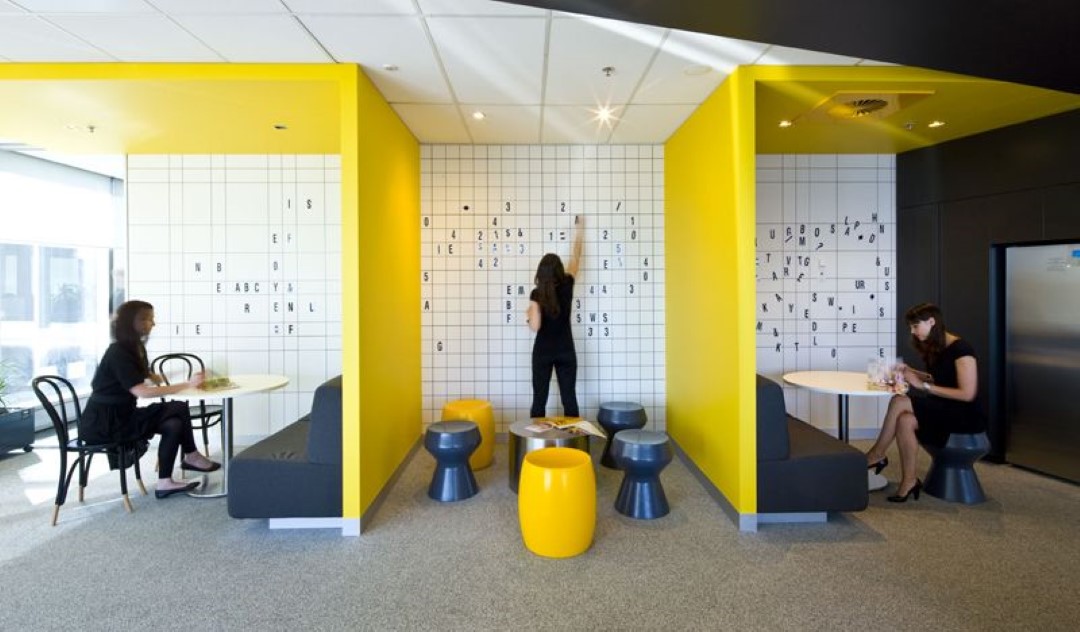 modern office space with yellow walls and people working