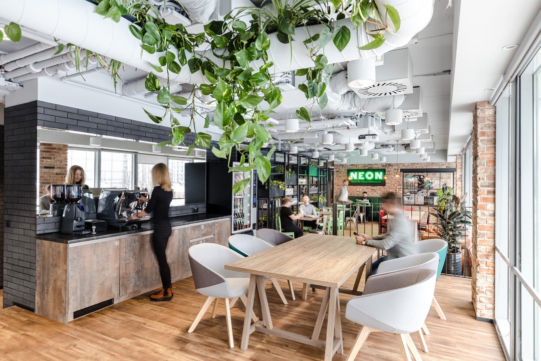modern office kitchen with plants and wooden table
