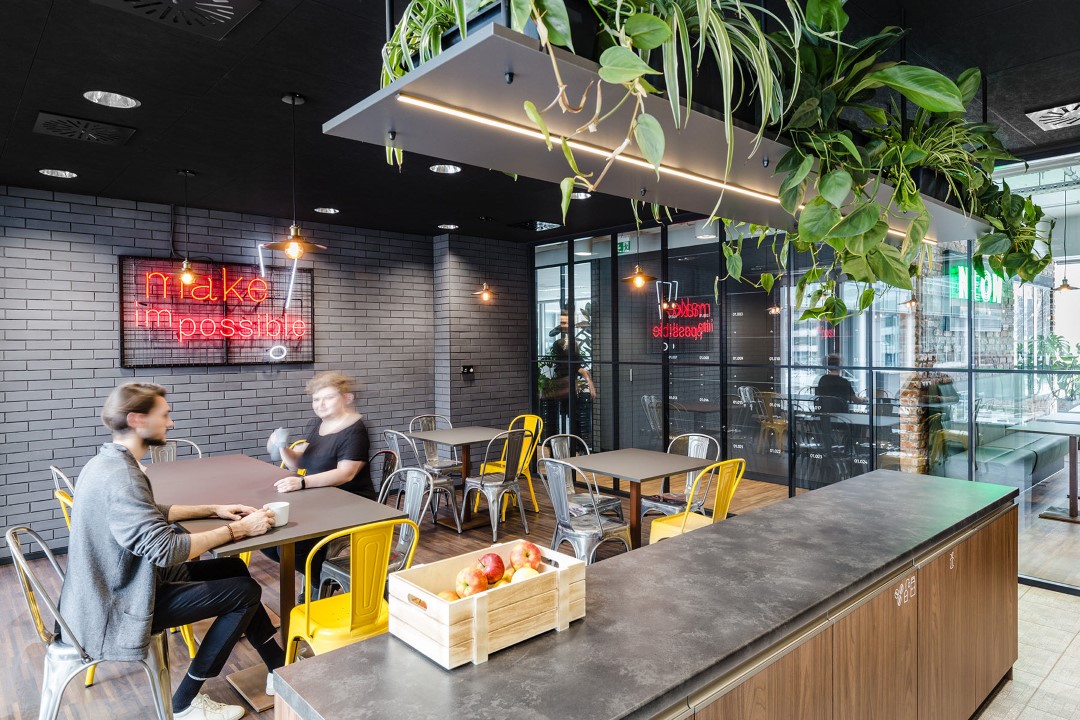 modern office kitchen area with people and plants