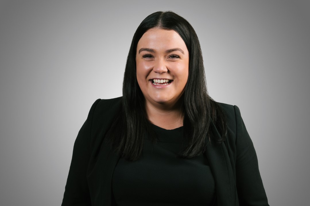 young woman with long black hair smiling at camera