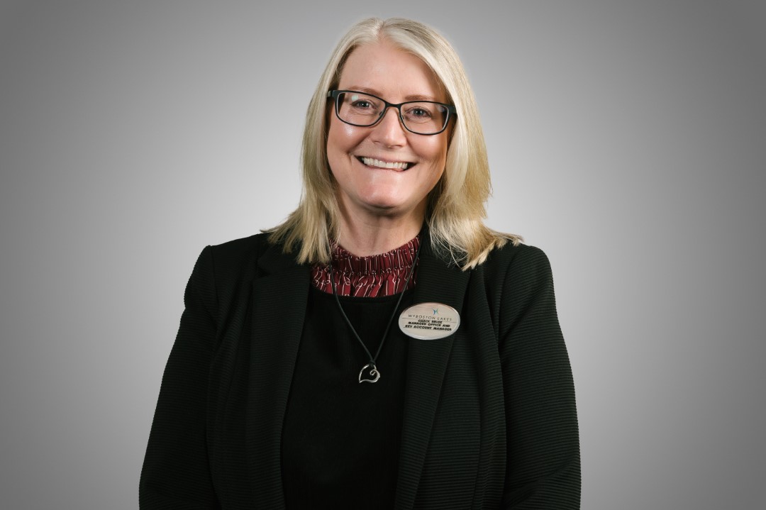 middle aged woman with glasses smiling wearing black jacket