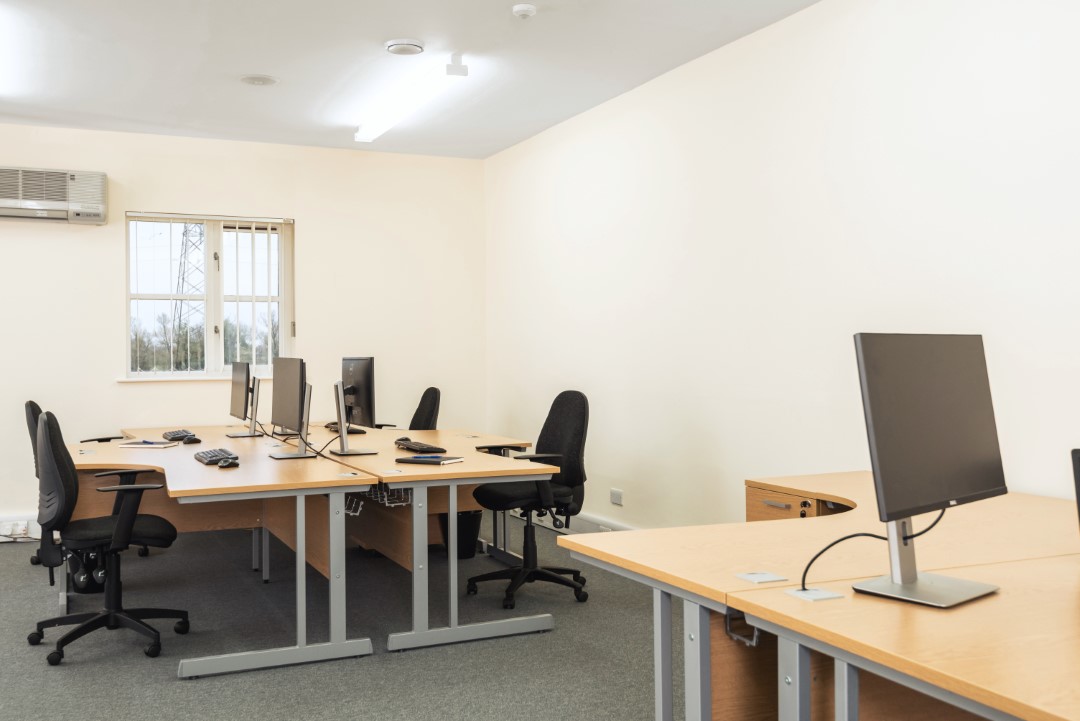 empty office with desks chairs and computer monitors