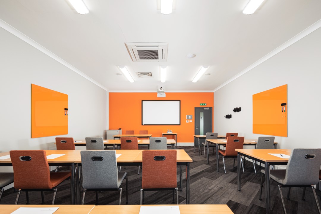 modern classroom with orange and grey chairs and desks