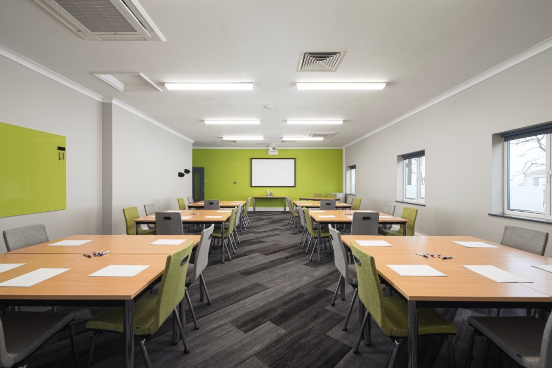 empty training room with tables chairs and whiteboard