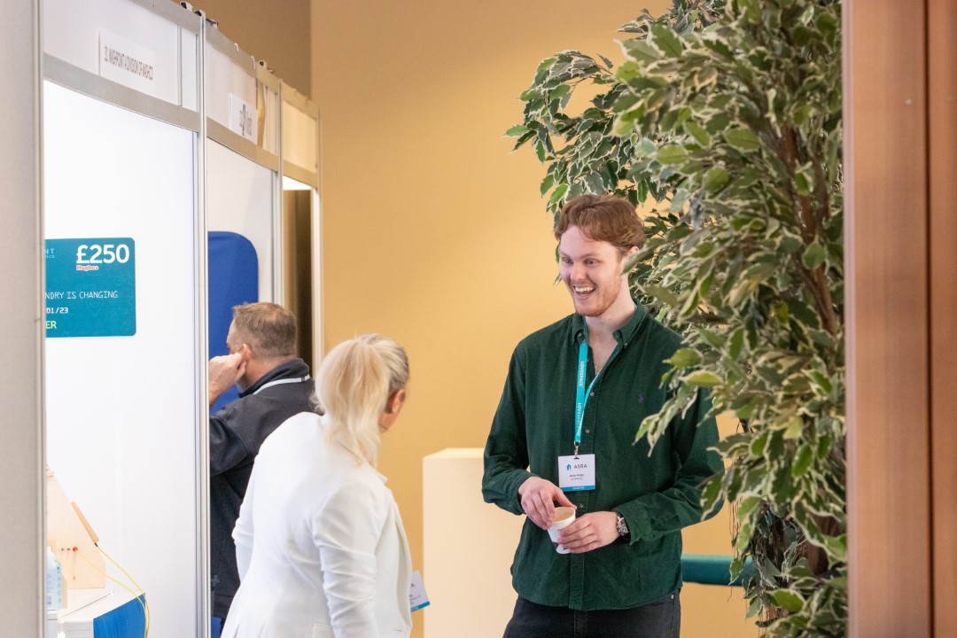 man and woman talking near indoor plant at event