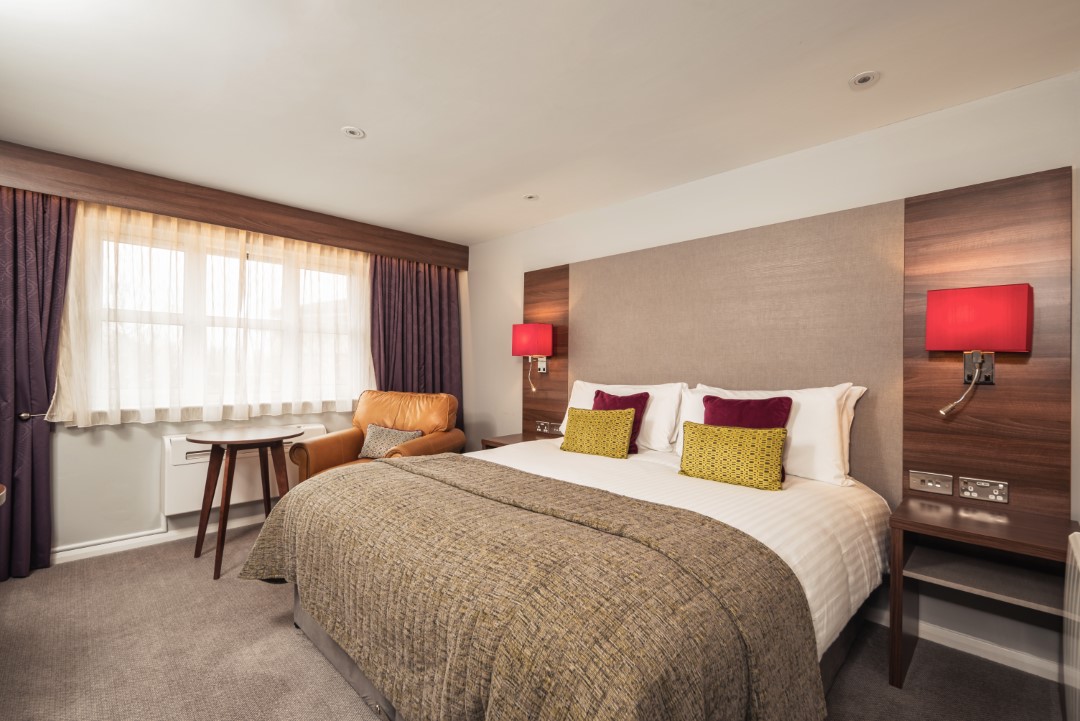 hotel bedroom with double bed armchair and window