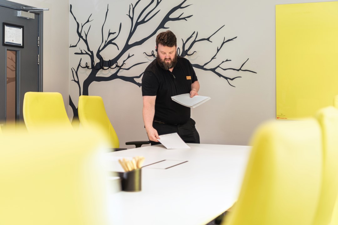 man in black shirt holding papers in meeting room
