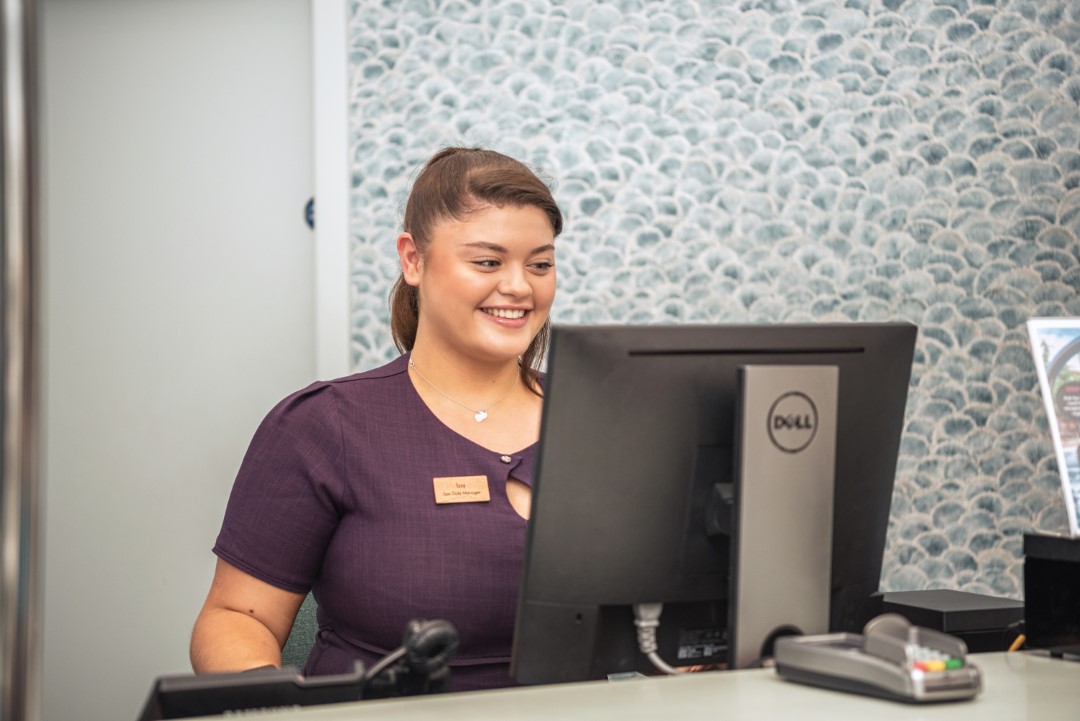 woman smiling working on desktop computer at desk