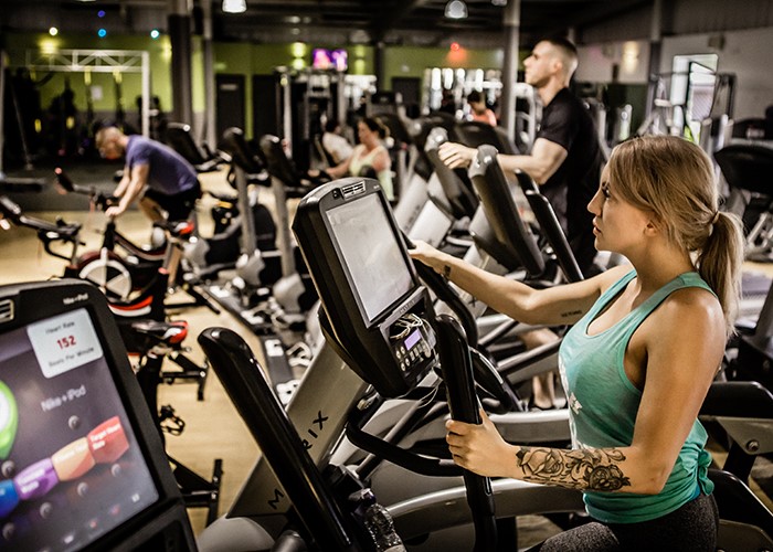 people exercising on machines in gym interior
