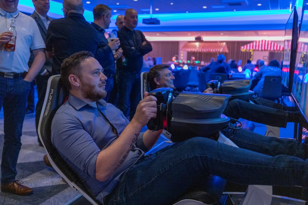 men playing virtual racing game in arcade room