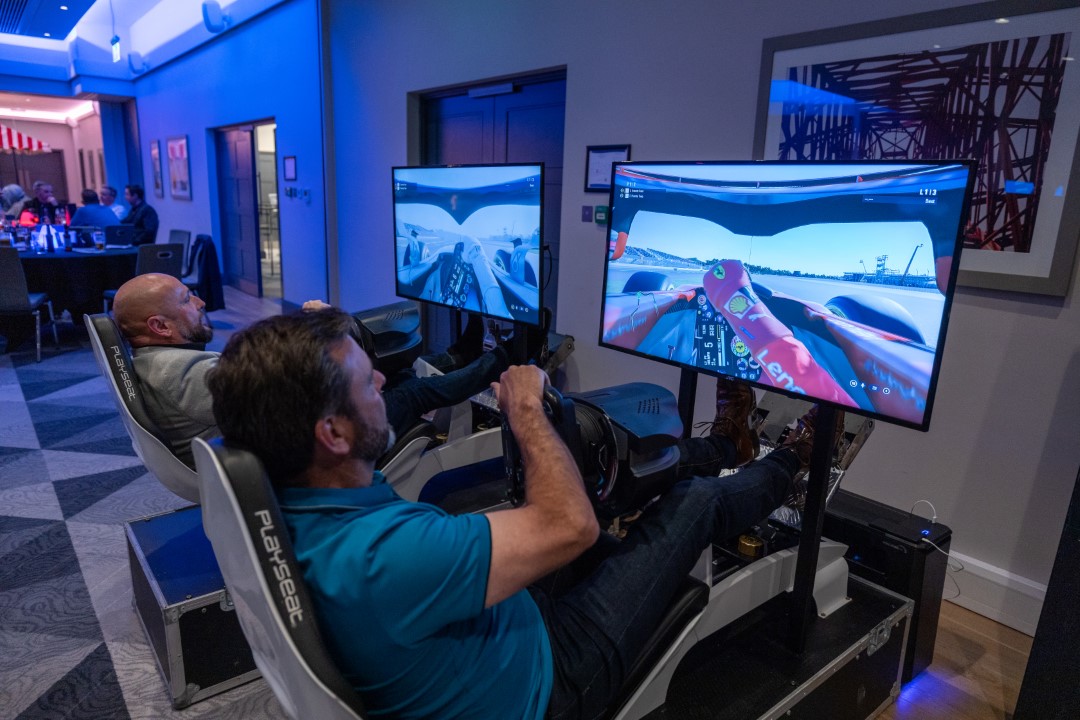 two men playing racing video games on simulators