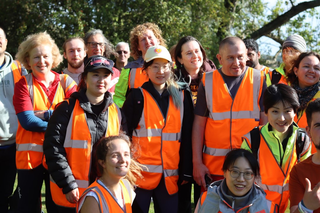 group of people outdoors wearing high visibility vests smiling