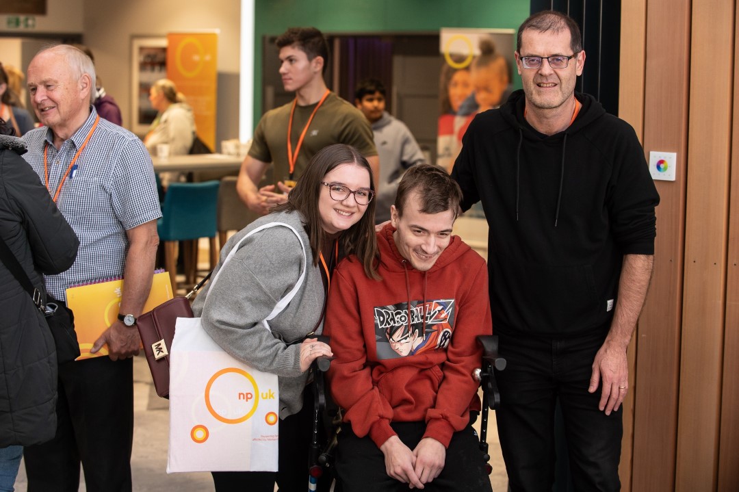 group of people smiling one person in wheelchair indoors