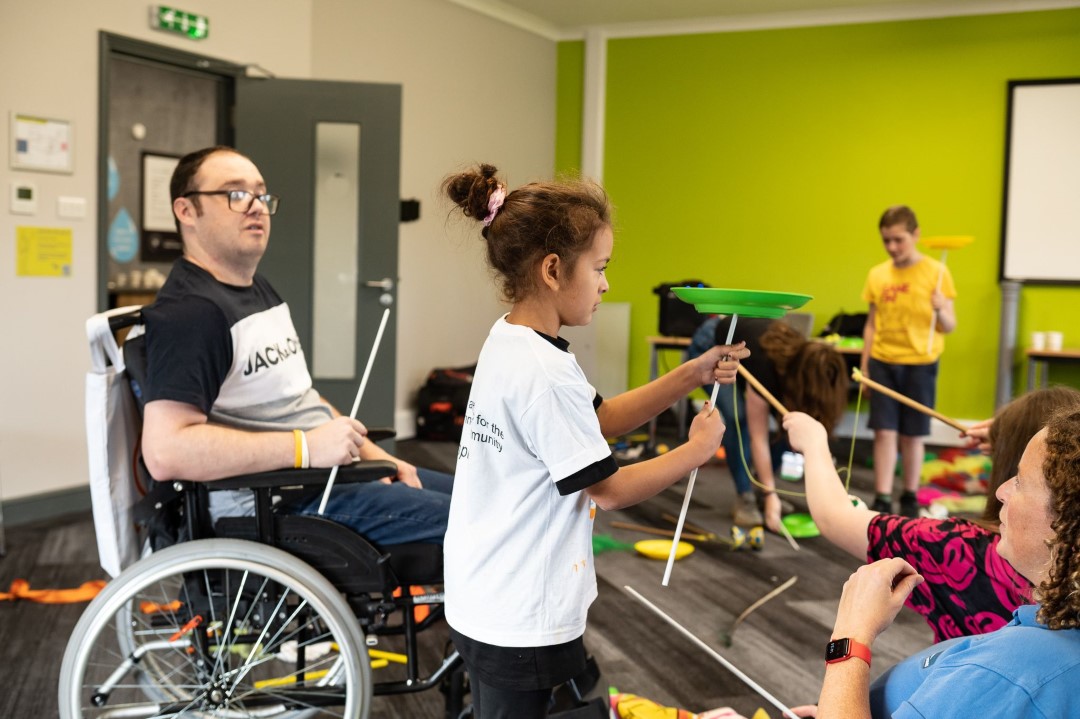 people spinning plates in inclusive group activity room