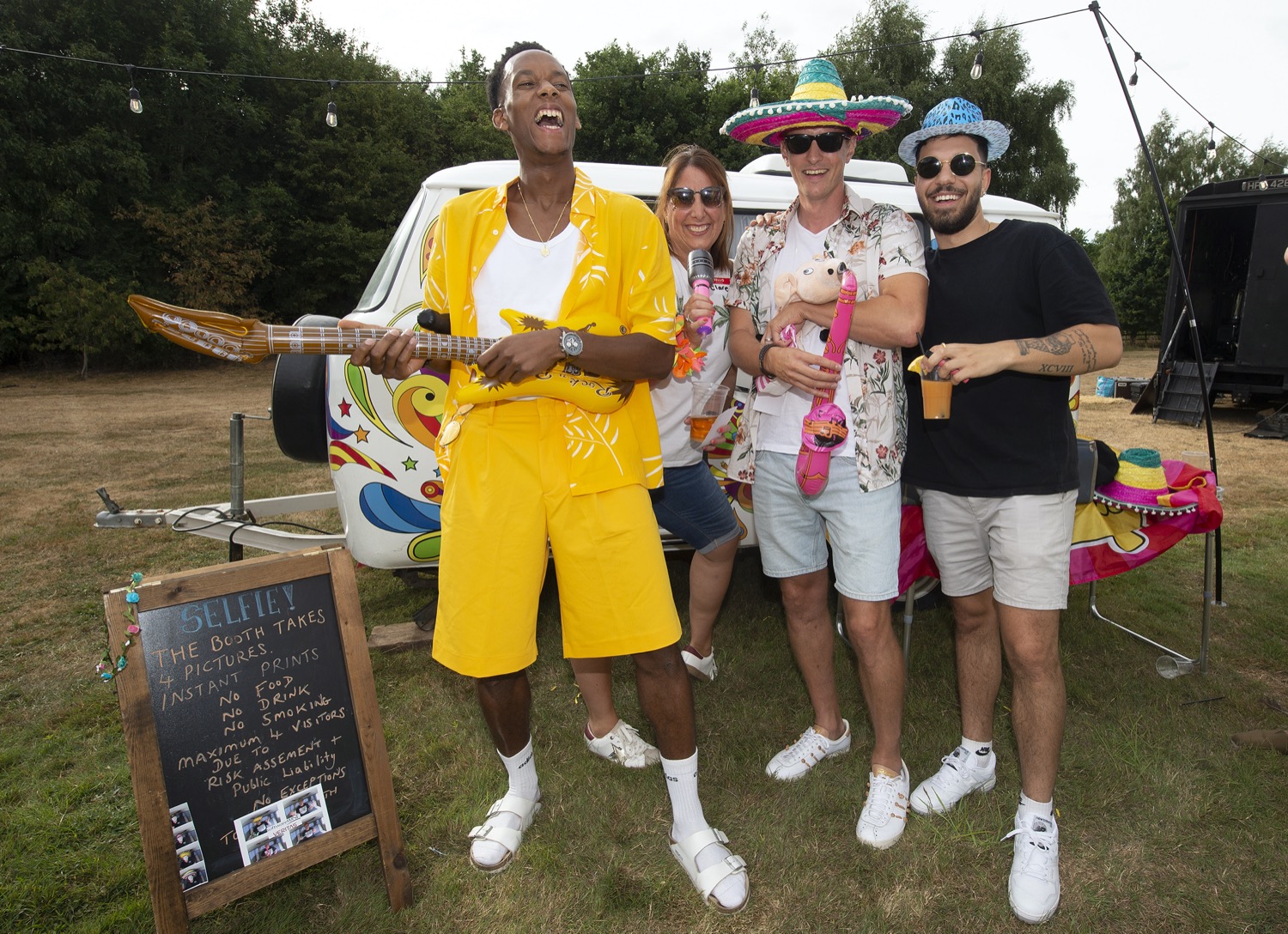 group of four people at outdoor party with inflatable instruments