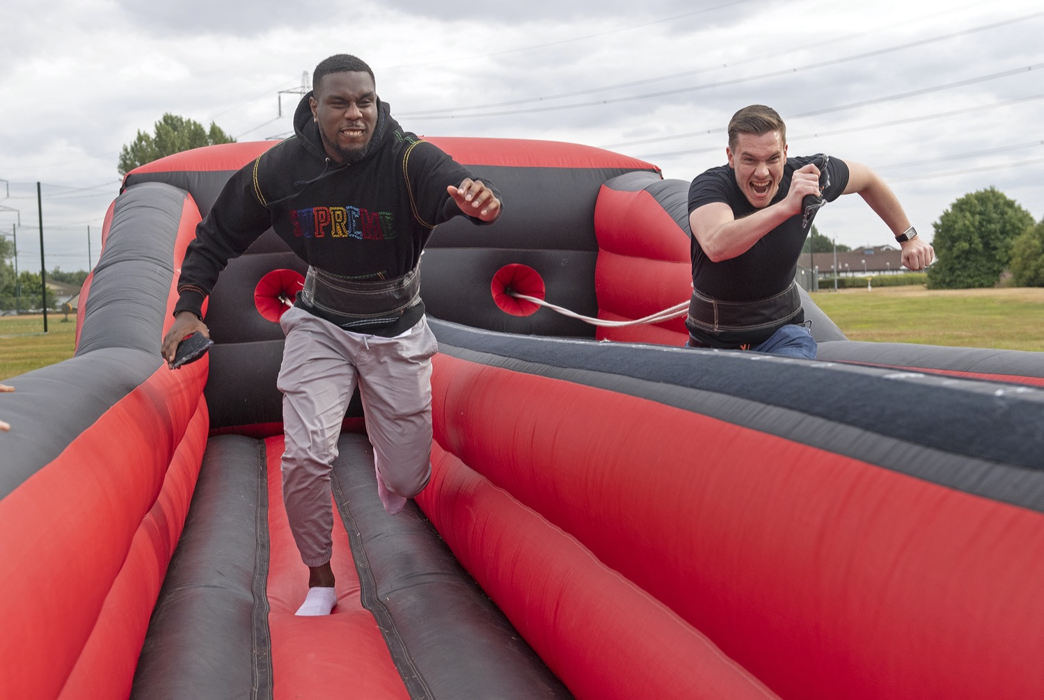 two men running on inflatable race track game