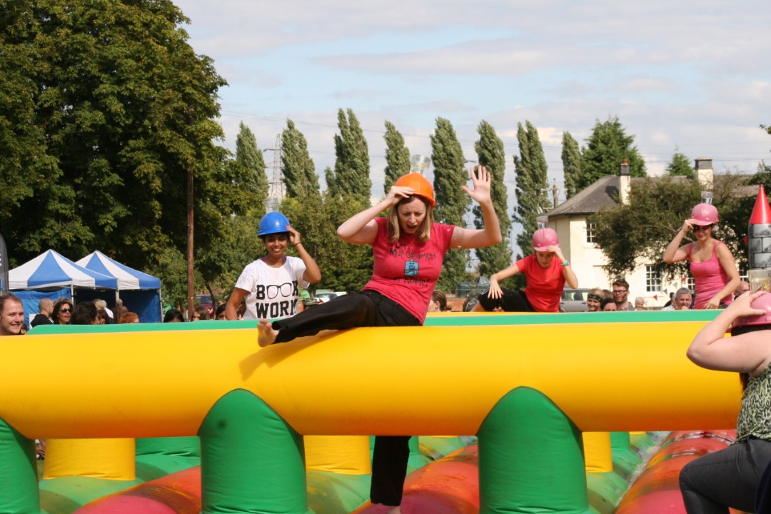 people wearing helmets playing inflatable game outside