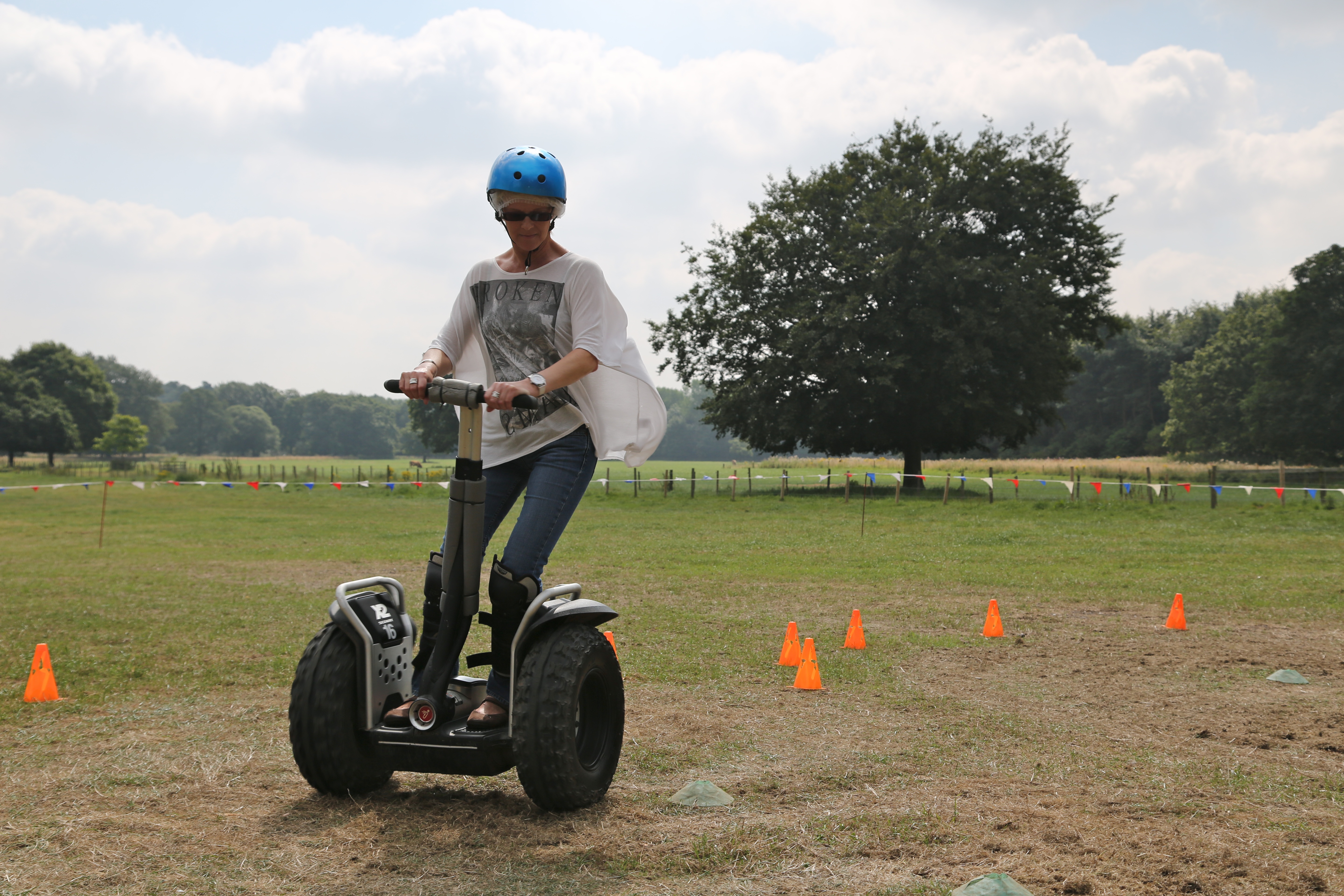 woman riding off road segway in field with helmet