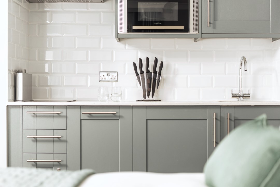 modern kitchen with grey cupboards knives and microwave