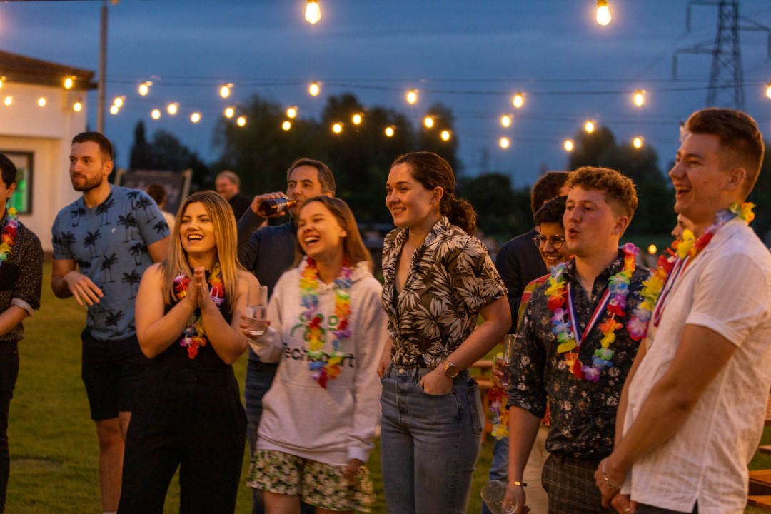 group of friends wearing leis at outdoor party at dusk