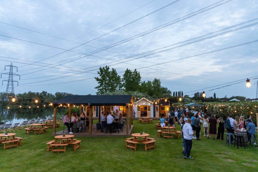 people socialising at outdoor garden party with string lights