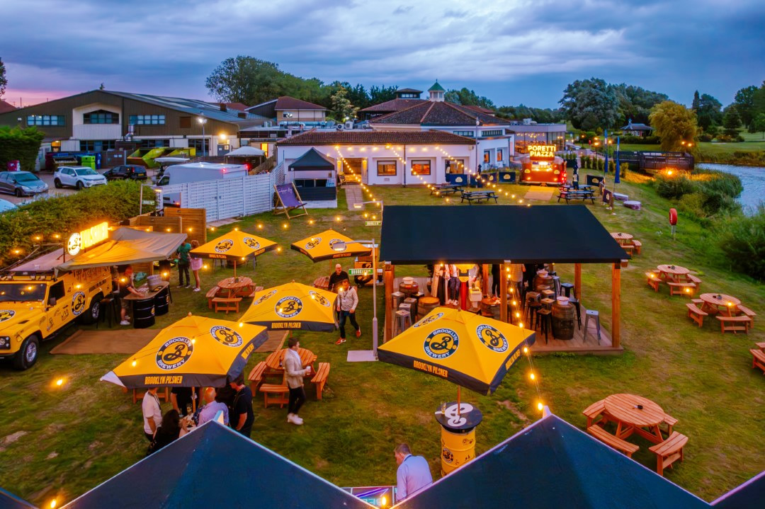 outdoor bar with yellow umbrellas people evening lights