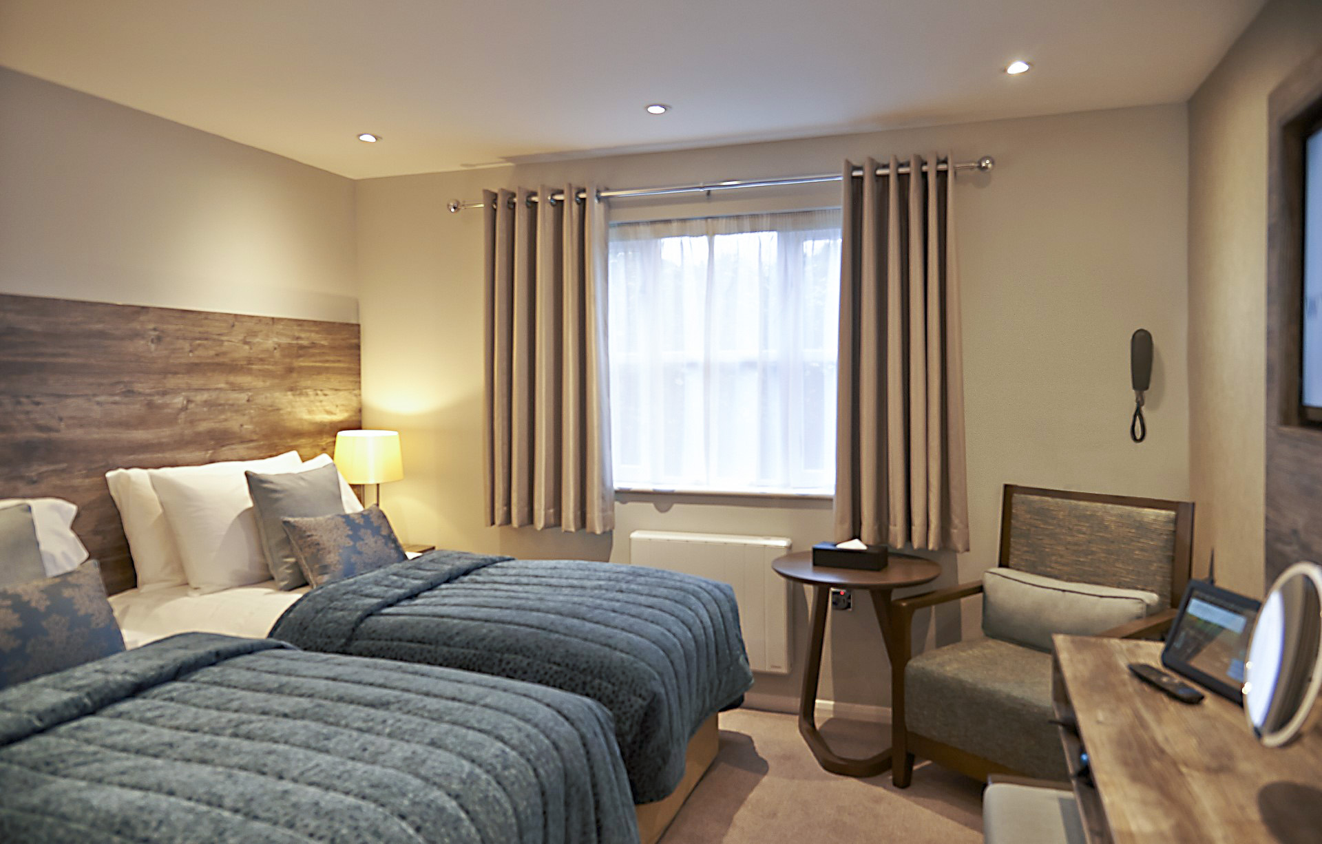 hotel bedroom with two single beds and armchair