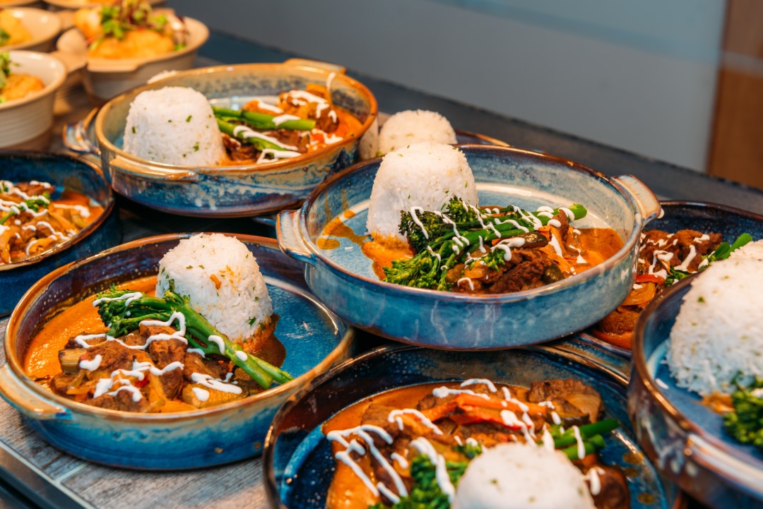 plates of curry with rice and greens