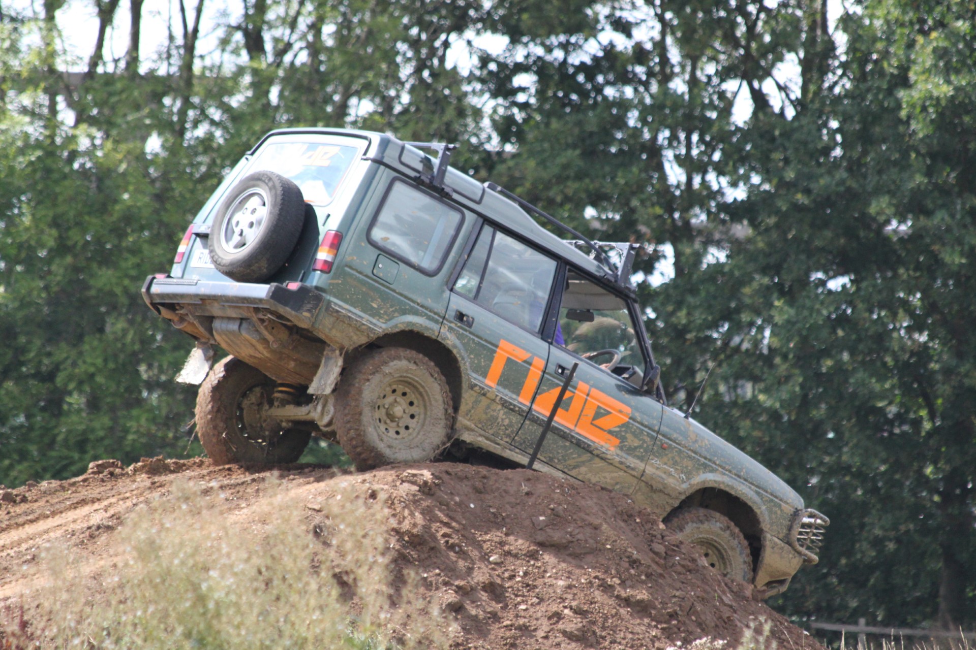 muddy offroad vehicle climbing steep dirt hill