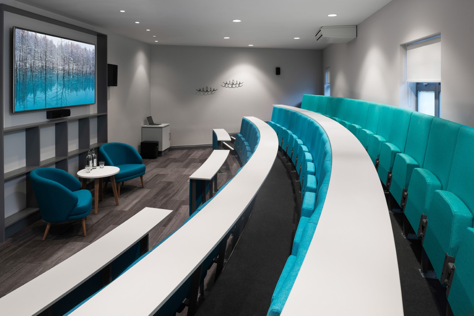 modern lecture theatre with turquoise seats and curved desks