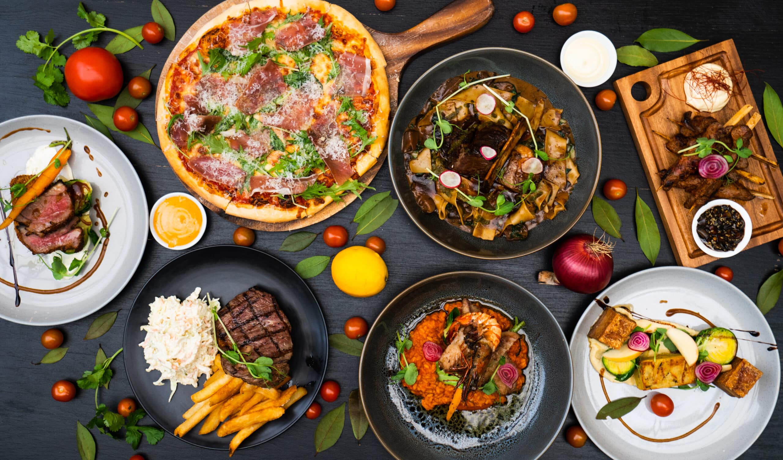 various gourmet dishes with meat pizza and vegetables