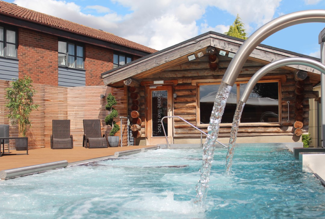 outdoor spa pool with water jets and wooden cabin