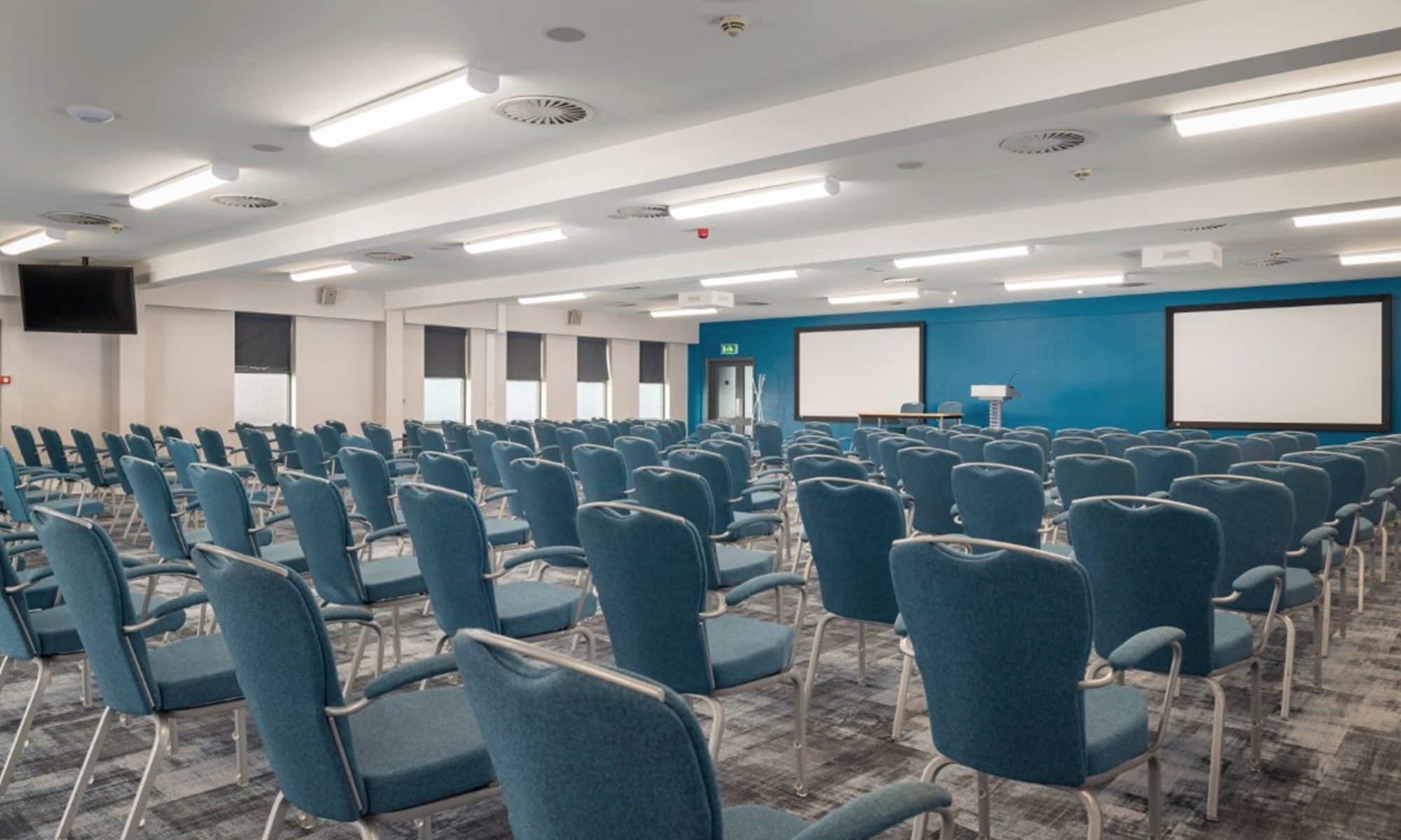 empty conference room with blue chairs and projection screens