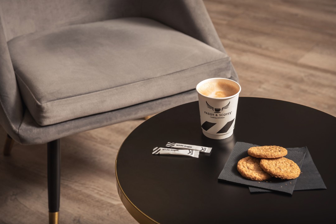 coffee sugar sachets and biscuits on black table