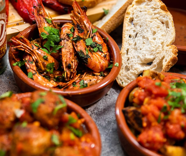 grilled prawns with herbs and bread slices in bowls